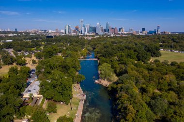 A beautiful distant view of the Barton Creek and a skyline of Austin, Texas