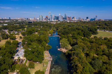 A beautiful distant view of the Barton Creek and a skyline of Austin, Texas clipart