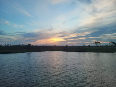 Kuzey Carolina 'da güneş doğarken bulutlu bir gökyüzünün altında güzel bir deniz manzarası.