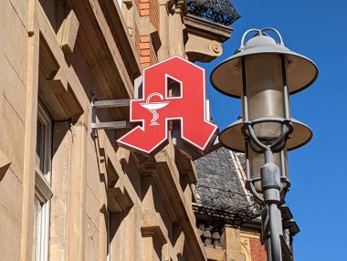 A shot of German red pharmacy symbol A for Apotheke pharmacy next to vintage lamp post in Heidelberg