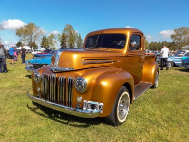 Old golden utility Ford pickup truck 1942 - 1947 in the countryside. Nature grass trees. Classic car show. Copyspace