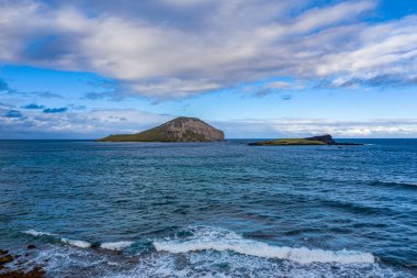 Mavi bulutlu gökyüzünün altında güzel bir okyanus manzarası