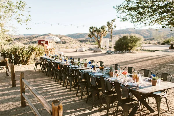 A modern outdoor event table setting in the desert