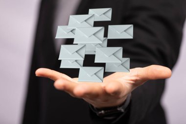 Bulanık erkek geçmişine sahip bir iş adamı elinde pek çok e-posta simgesi konsepti