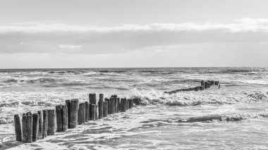 Buhnen brechen eine Welle an der Nordsee