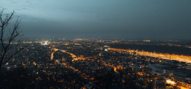 Büyük, modern bir şehrin gece ufkunun panoramik görüntüsü.