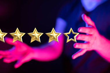 Karanlık bir arkaplanda yıldız simgeleri tutan bir kişi