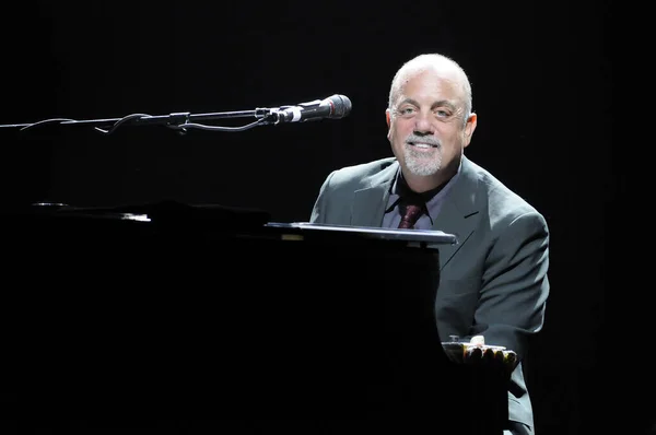 A portrait shot of Singer, songwriter, pianist, legend Billy Joel  performing live at the Honda Center in Anaheim, California with black background