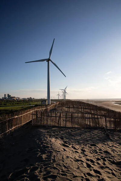 A vertical shot of a row of wind turbines on Caota dune beach in Taiwan