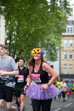 Vitality London 'da ayçiçeği bandı takmış bir kadın koşucunun dikey çekimi..
