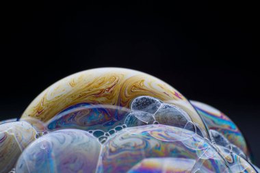 Cluster soap bubble. Close-up. Black background. Bright colors. Side view. Imitation of an unknown planet. Science fiction