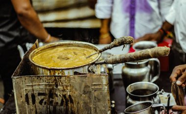 Caddenin yanındaki çay dükkanında bir Hint çayı kaynıyor.
