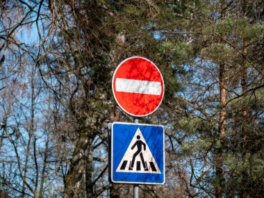 Mavi geçiş işaretinin üzerinde 'Sürücülere Giriş Yasaktır' yazan yuvarlak kırmızı bir tabela