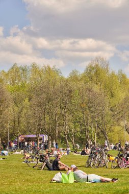 Poznan, Polonya 'daki parkta yeşil çimlerin üzerinde dinlenen insanlar