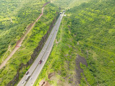 Çevresi yemyeşil ve yemyeşil olan otobanın havadan görünüşü
