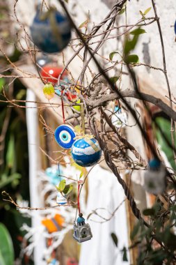 Santorini 'deki dalların, bulanık bir arkaplan üzerinde yılbaşı süslerinin dikey yakın çekimi.
