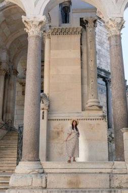 Hırvatistan 'ın Split kentindeki Diocletian Sarayı' nın kemerli sütunları altında genç bir kadının yakın çekimi