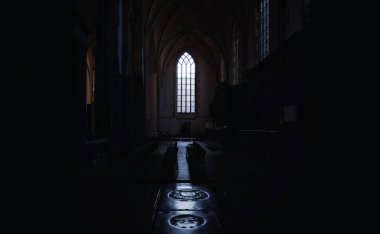 Pencereden gelen ışığın olduğu karanlık bir odanın içeriden görünüşü.