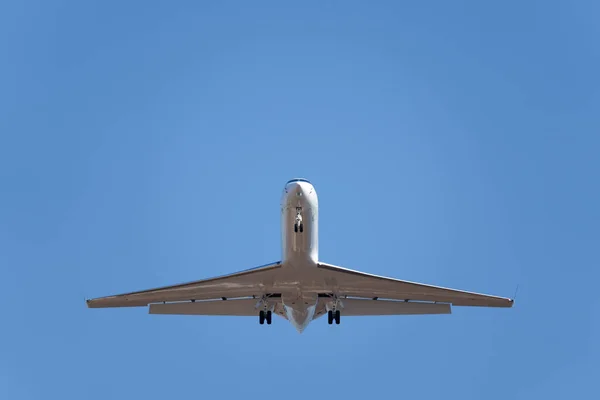 A low angle of a private jet landing at Lunken Airport,Ohio against a blue cloudless sky on a sunny day