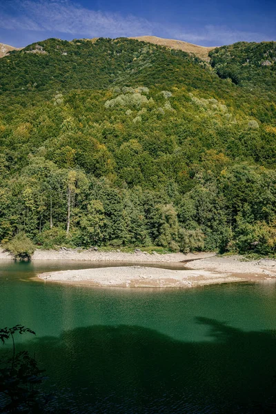 在黑山一个阳光明媚的日子里 湖面相对于绿林覆盖的小山的垂直面 — 图库照片