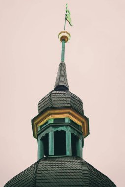 Arka planda bulutlu gökyüzü olan bir kilisenin kulesi.