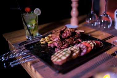 Bir tabak tavuk ve sığır barbeküsü yanında da bir bardak taze mojito.