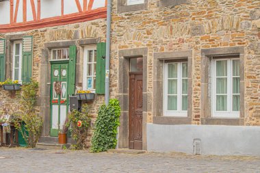 Çiçekleri ve bitkileri olan binaların eski kapı ve pencerelerinin güzel bir görüntüsü.