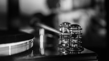 Bulanık bir arkaplanda bir döner tablonun hız göstergesinin gri tonlu bir kapanışı