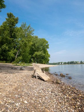 Güneşli bir günde sakin denizin kıyısındaki kırık güneşlik.