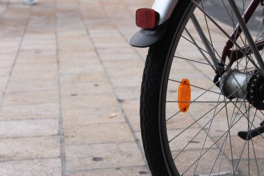 Asfaltlı kaldırımda bir bisiklet tekerleğinin yakın çekimi.