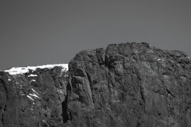 Karla kaplı bir dağın gri tonlu görüntüsü.