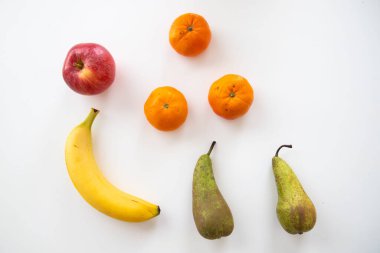 Beyaz yalıtılmış arka planda portakal, muz, elma ve armutların üst görüntüsü