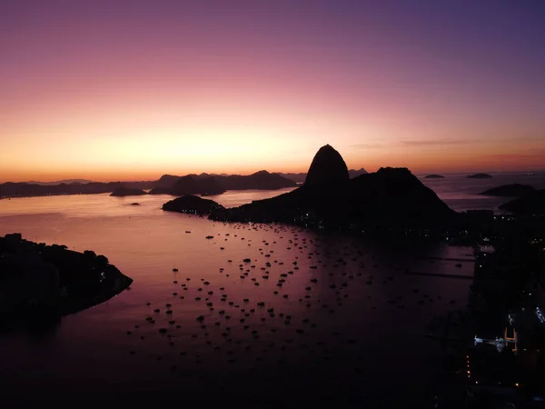 Silhouettes of mountains and boats at the shore in Rio de Janeiro during sunset