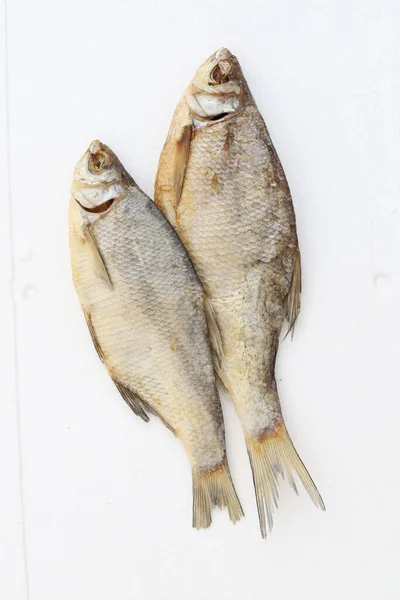 一条垂直拍摄的两条冷烟熏烤的里海蟑螂鱼在白色背景上 — 图库照片