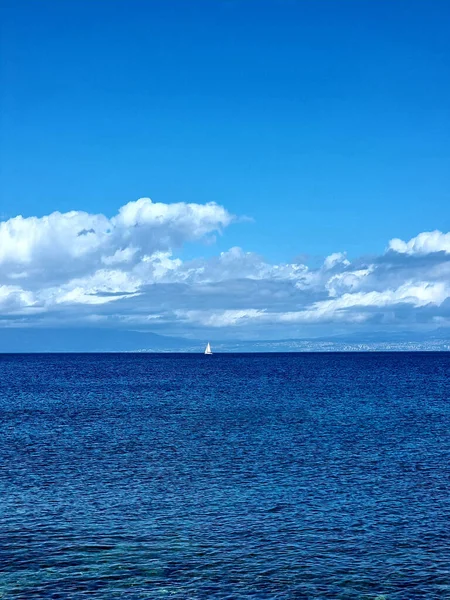 Vertical Shot Blue Water Sea Boat Sailing Far Away Cloudy —  Fotos de Stock