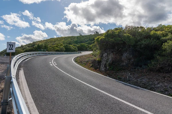 Tepede arabasız, gündüzleri 22 numaralı bilgi panosu olan virajlı bir yol.