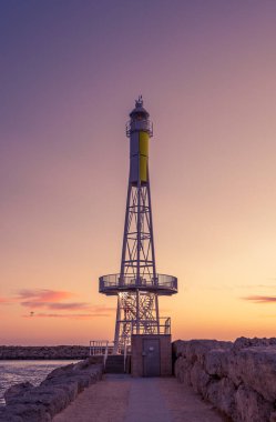 Bir roket gemisinin dikey görüntüsü. Gün batımında gökyüzüne bakan kayalarla dolu bir gözlem kulesi.