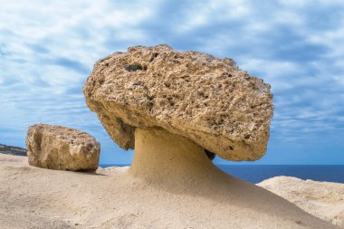 Yumuşak ve sert bir kaya tabakasının farklı bir şekilde aşınması sonucu oluşan mantar şekilli kaya veya kaya kaidesi. Gozo, Malta kayalıkları boyunca bulundu.