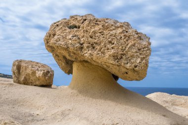 Yumuşak ve sert bir kaya tabakasının farklı bir şekilde aşınması sonucu oluşan mantar şekilli kaya veya kaya kaidesi. Gozo, Malta kayalıkları boyunca bulundu.