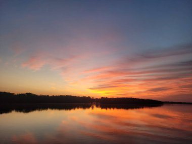 Kuzey Carolina 'da güneş doğarken bulutlu bir gökyüzünün altında güzel bir deniz manzarası.