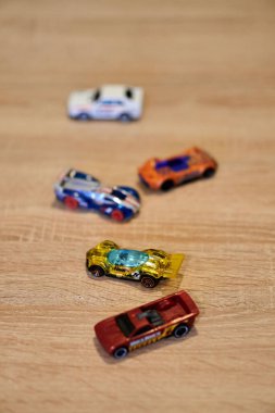 Mattel Hot Wheels 'in tahta yüzeydeki oyuncak arabalarının dikey yakın çekimi..