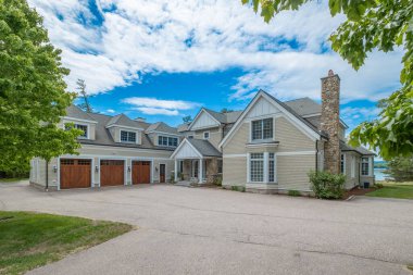 Arkasında bulutlu ağaçlarla çevrili iki katlı kulübeler.