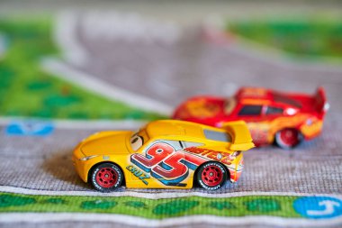 Disney Pixar Cars filmindeki oyuncak model arabalar oyun mat üzerinde.