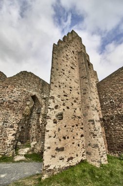 Almanya 'nın Monreal Eifel kentindeki Lowenburg kalesinin mavi bulutlu gökyüzü enkazının dikey görüntüsü.