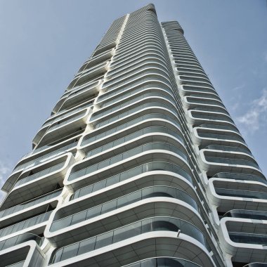 Mavi parlak gökyüzünün altındaki beyaz binanın alçak açılı görüntüsü.