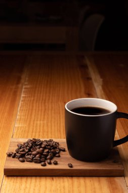 Tepsinin üzerinde kavrulmuş fasulye olan bir fincan kahve.