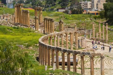 A group of people at the ancient cultural heritage of Oval Forum in Jerash, Jordan