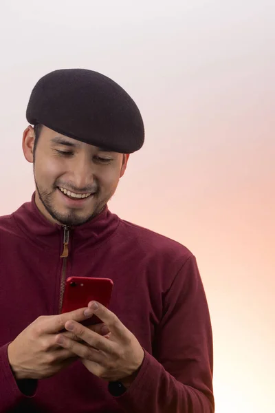 Kırmızı Cep Telefonuna Şapka Takan Latin Bir Gencin Dikey Çekimi — Stok fotoğraf