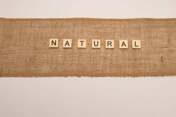 Natural Concept Letter Tiles Laid Hessian Jute Cloth Isolated White — Stock Photo, Image