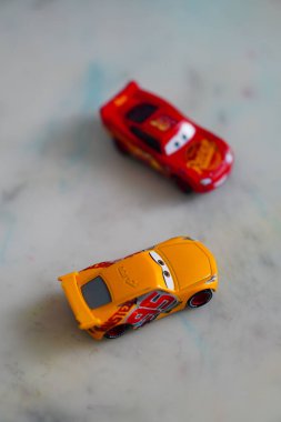 A vertical shot of Mattel Cruz Ramirez and Lightning McQueen toy model cars of the Disney Cars movie